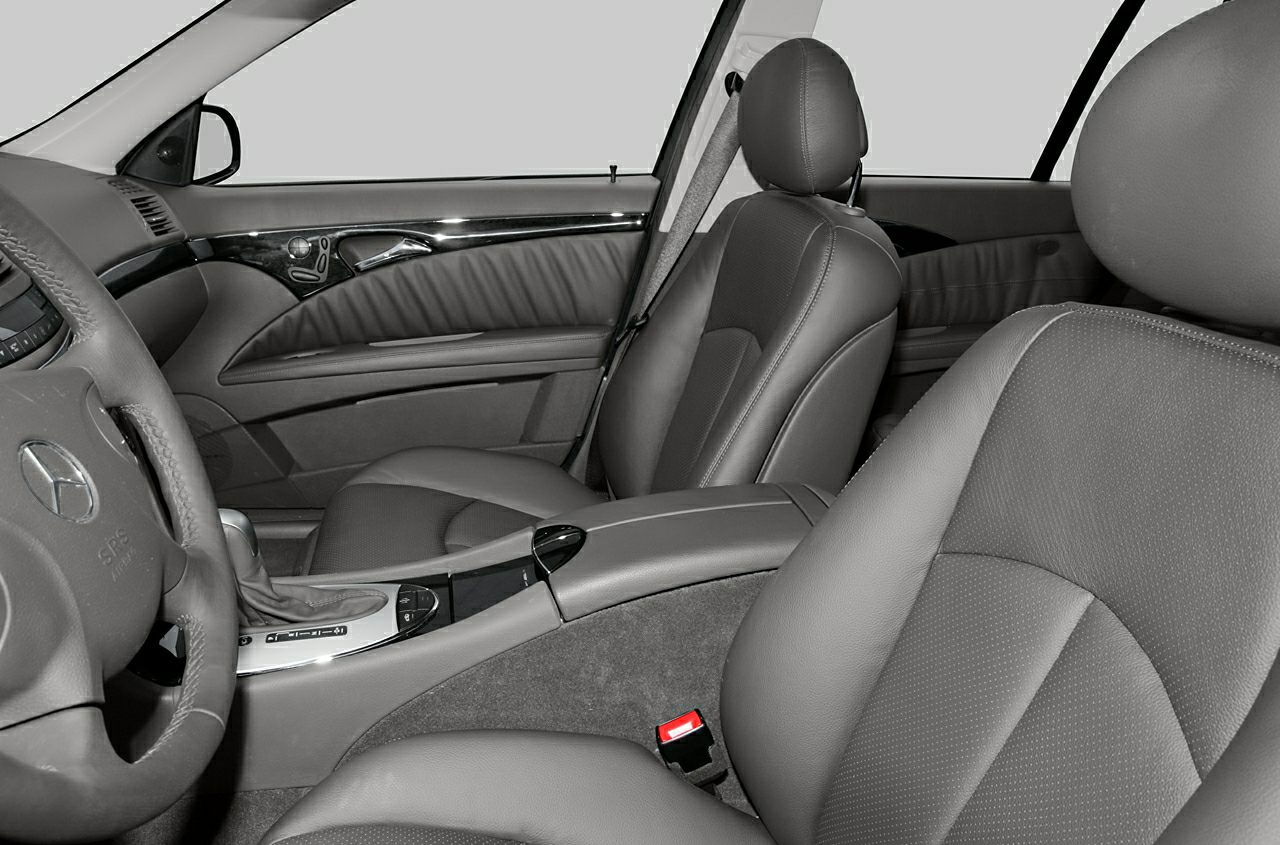Front leather seats with steering wheel and center console in a car interior