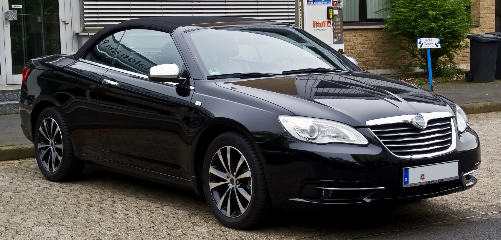Black convertible coupe showing front and side view with alloy wheels.