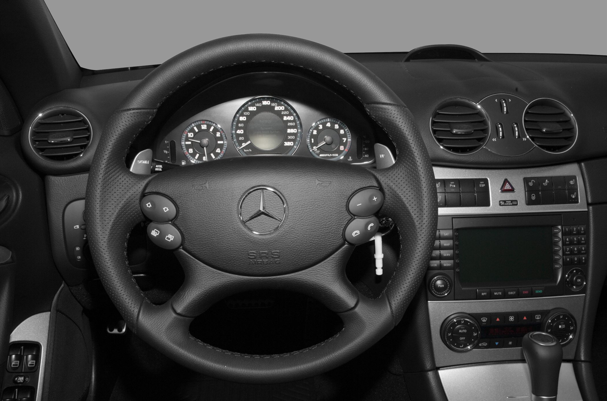 Close-up of steering wheel and dashboard with instruments and controls