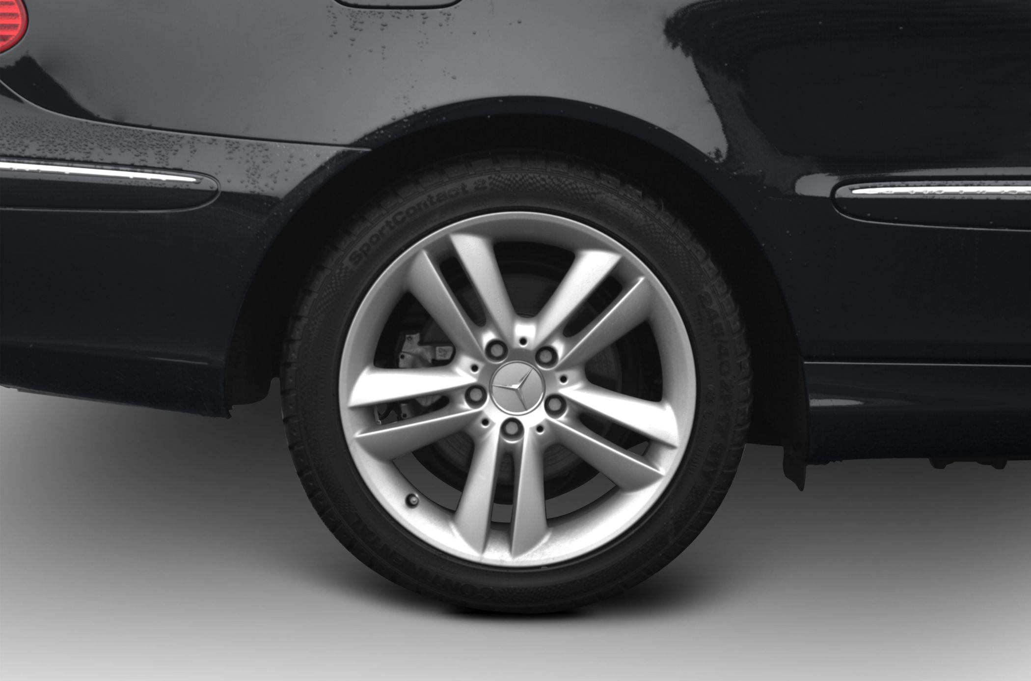 Closeup of silver alloy wheel with multi-spoke design and tire