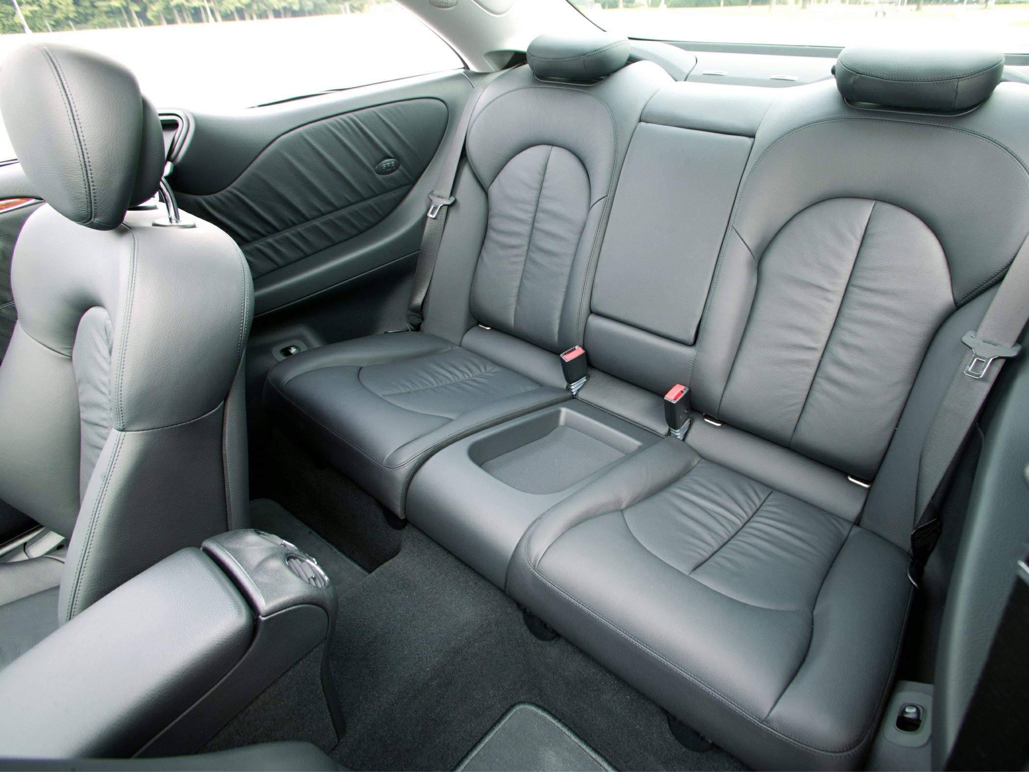 Rear black leather seats with integrated headrests and seat belts.