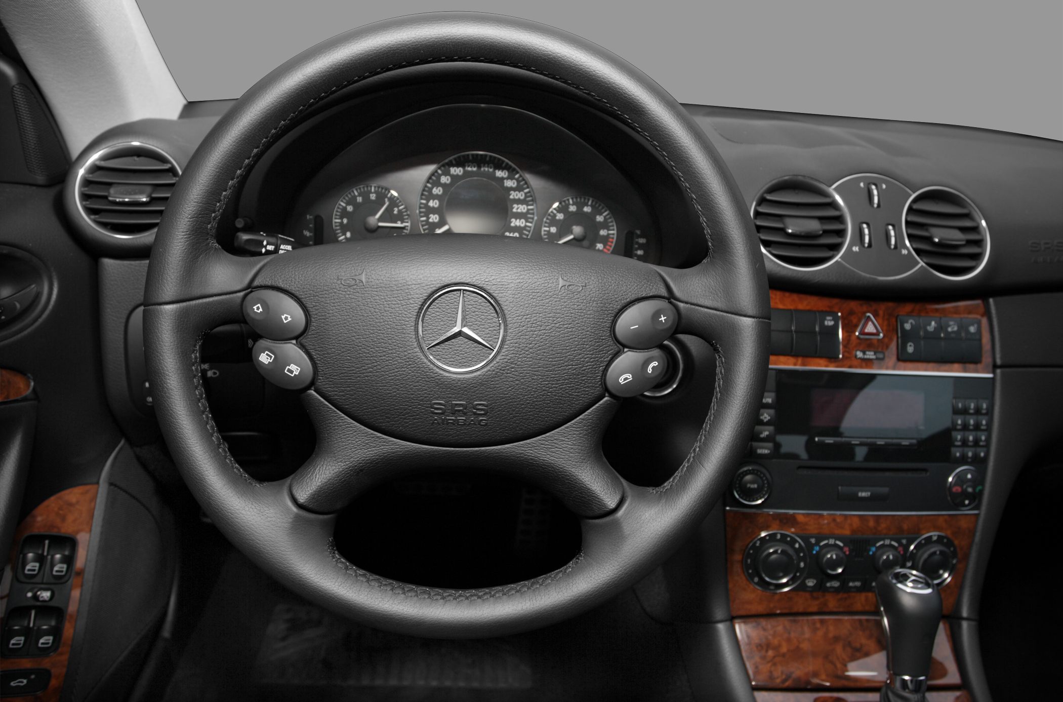 Steering wheel with controls and wood-trimmed dashboard
