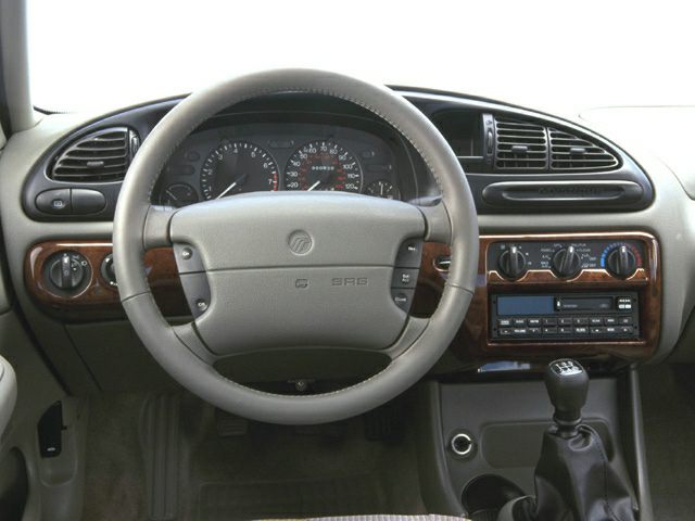 Dashboard and steering wheel with manual gear shift and wood trim