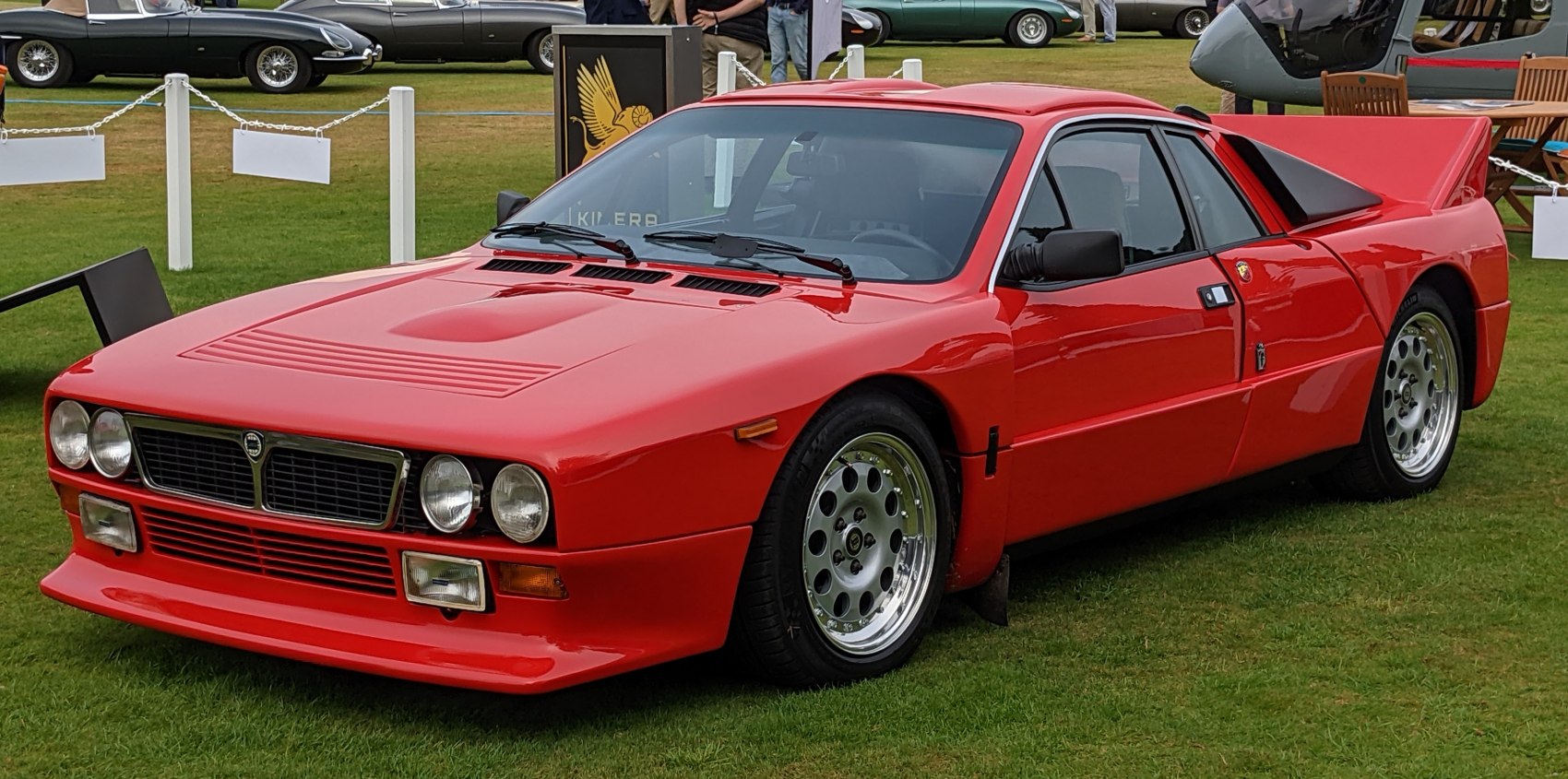 Vintage red coupe with circular headlights and a large rear spoiler