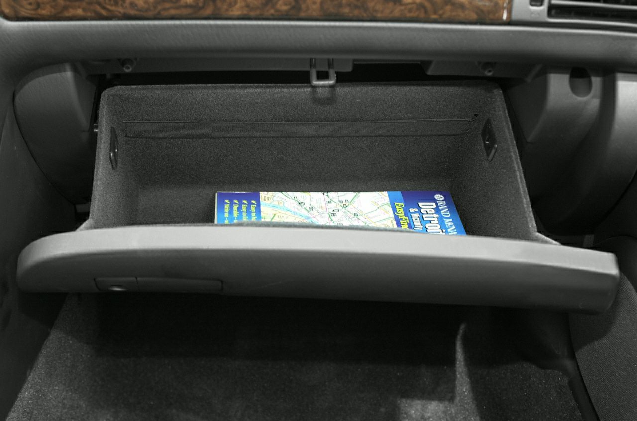 Open glove box with map inside in car interior storage compartment