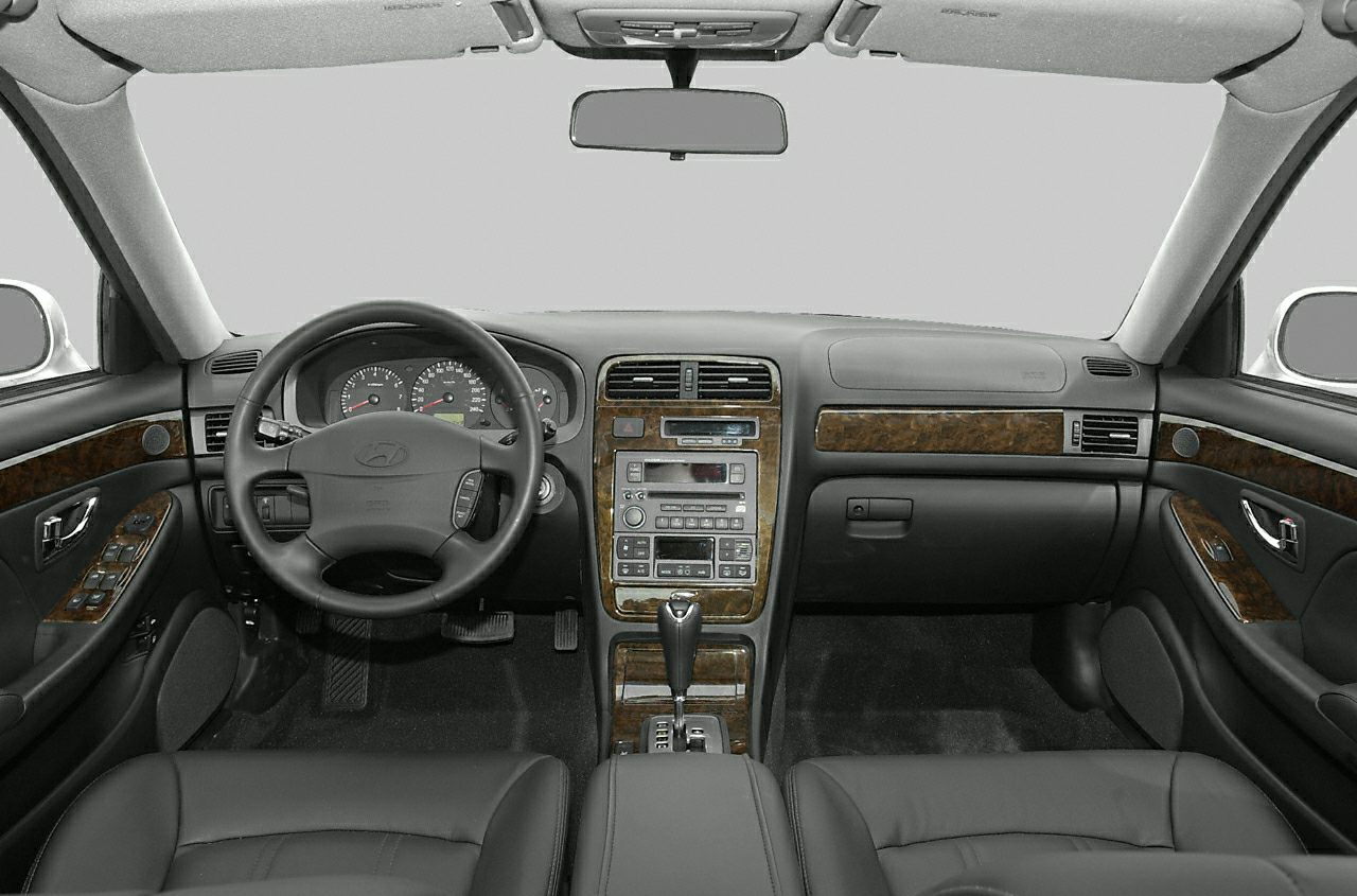 Car interior dashboard with wood panel trim and steering wheel