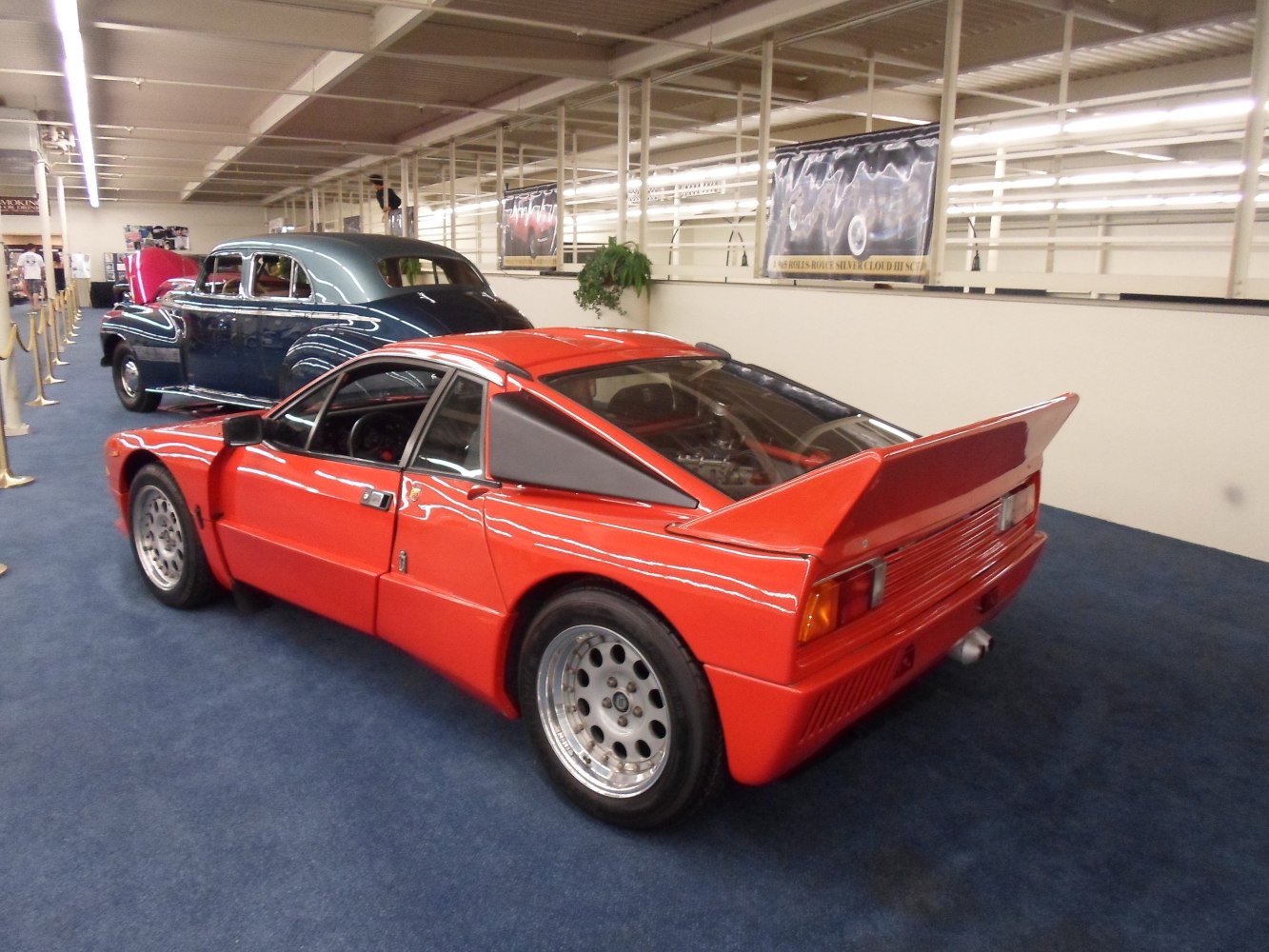 Red mid-engined sports car with rear wing and angular rear design