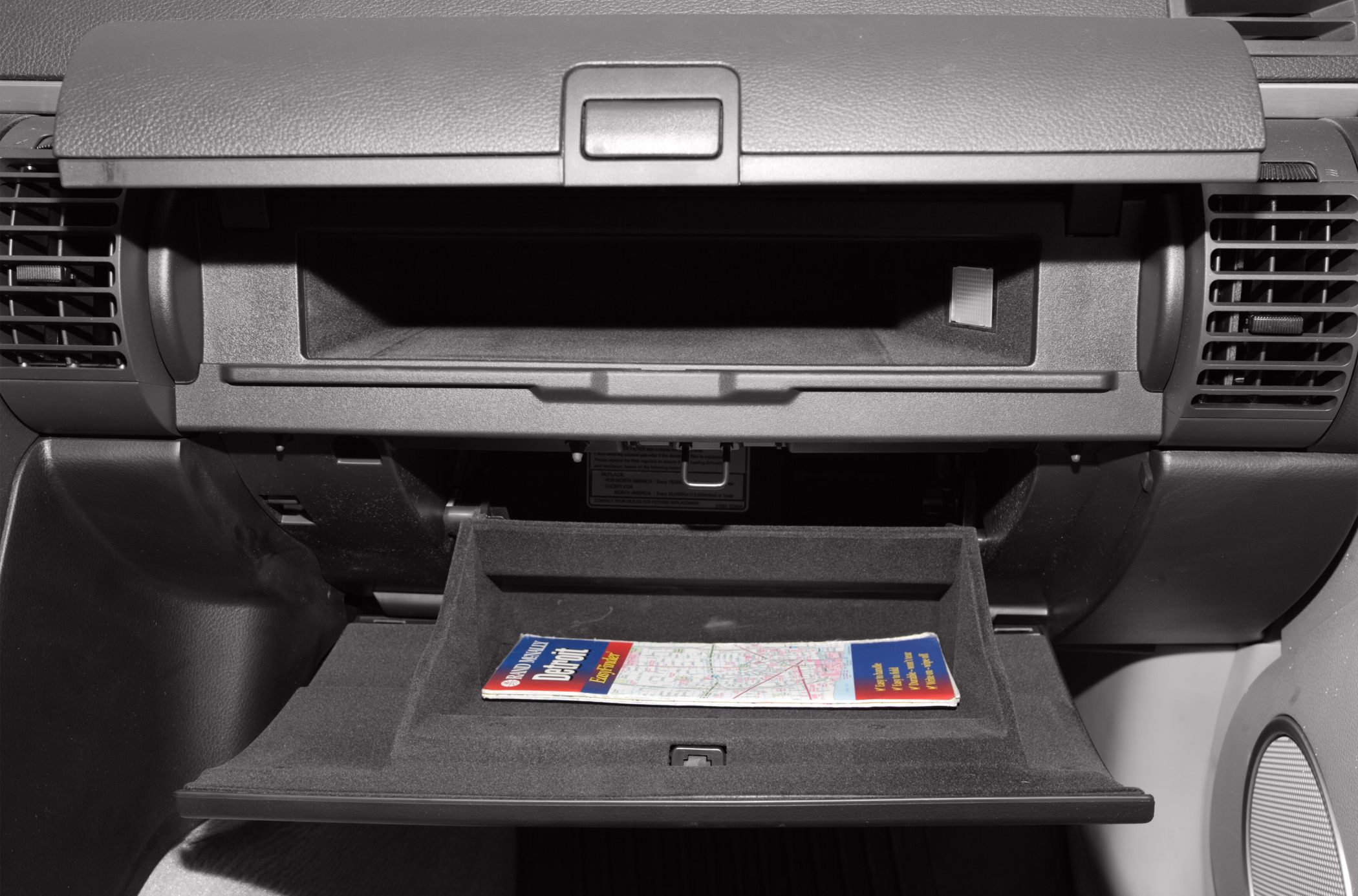 Open glovebox and dashboard air vents inside a car