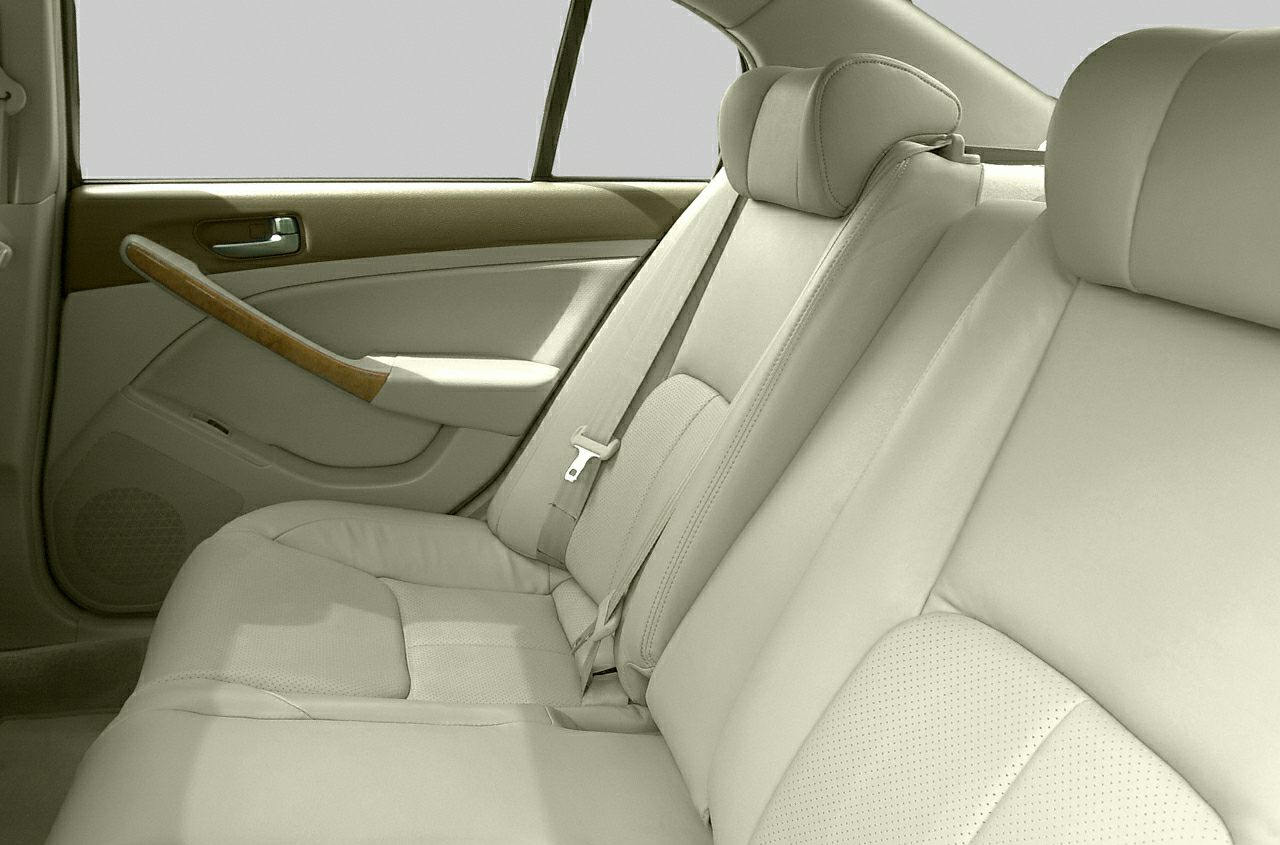 Rear beige leather seats with headrests and wood trim door panel