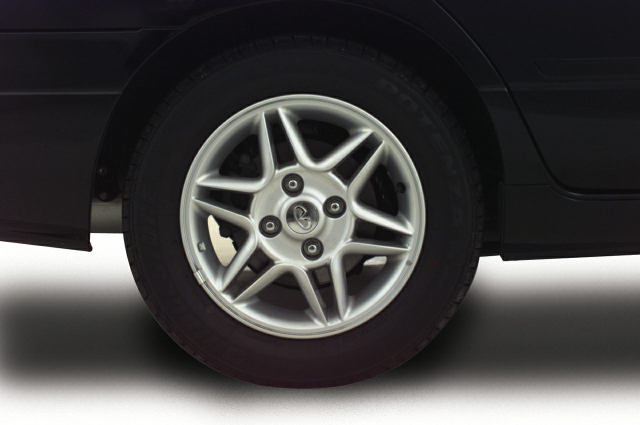 Close-up of a silver 5-spoke alloy wheel with branded center cap and tire.