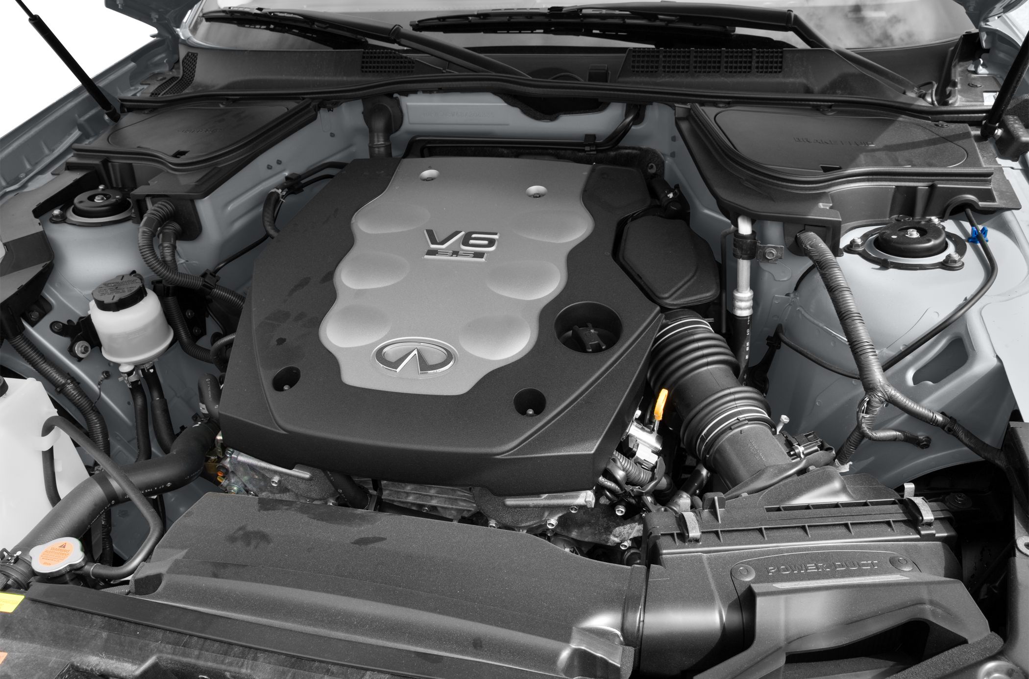Close-up of a V6 3.5L engine bay with engine cover and air intake system.