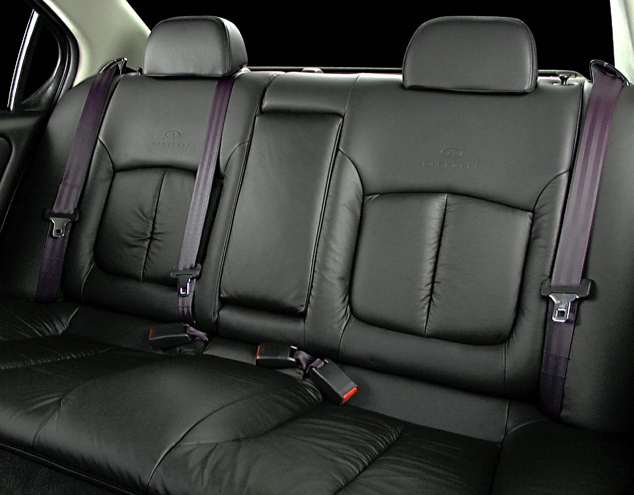 Black leather rear seats with integrated headrests and seat belt setup