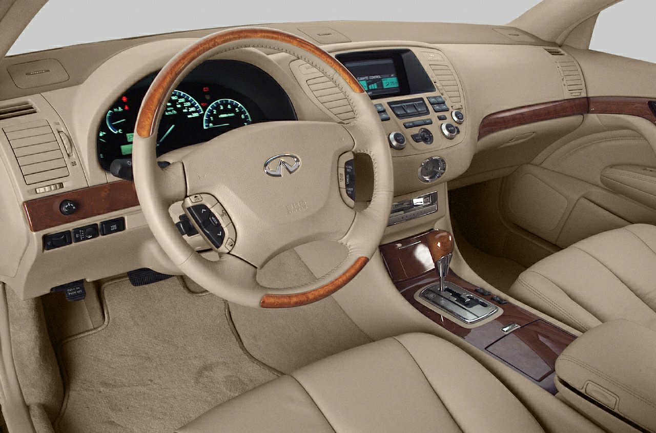 Luxurious beige interior with wood-trimmed steering wheel and detailed dashboard controls