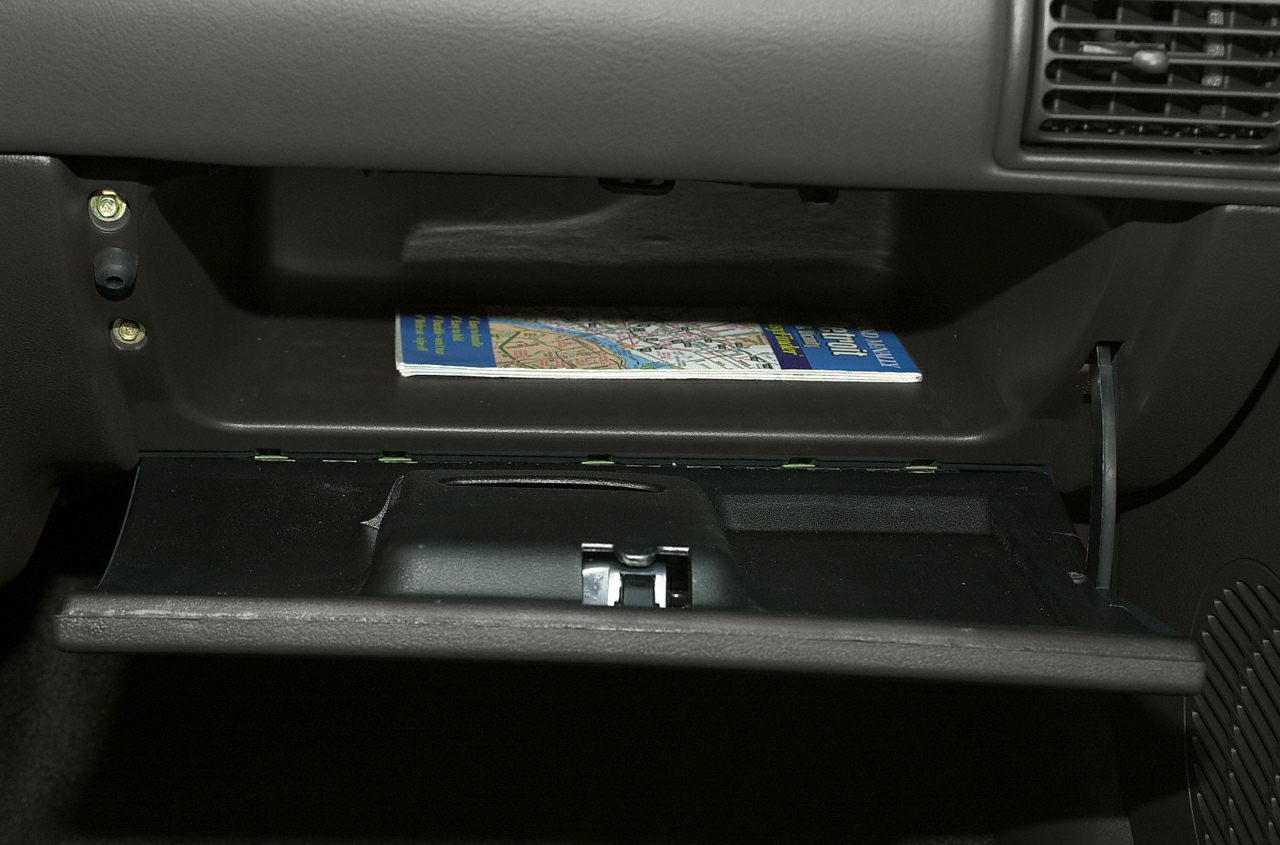 Open glove compartment with booklet inside, showing interior storage design.