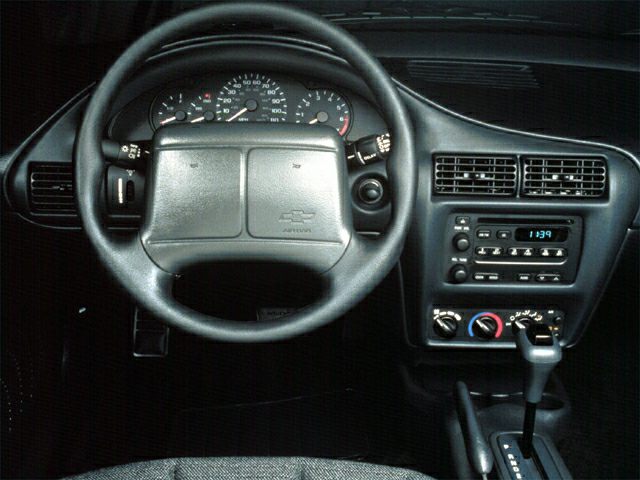 Dashboard and steering wheel interior with control panel and gear lever.