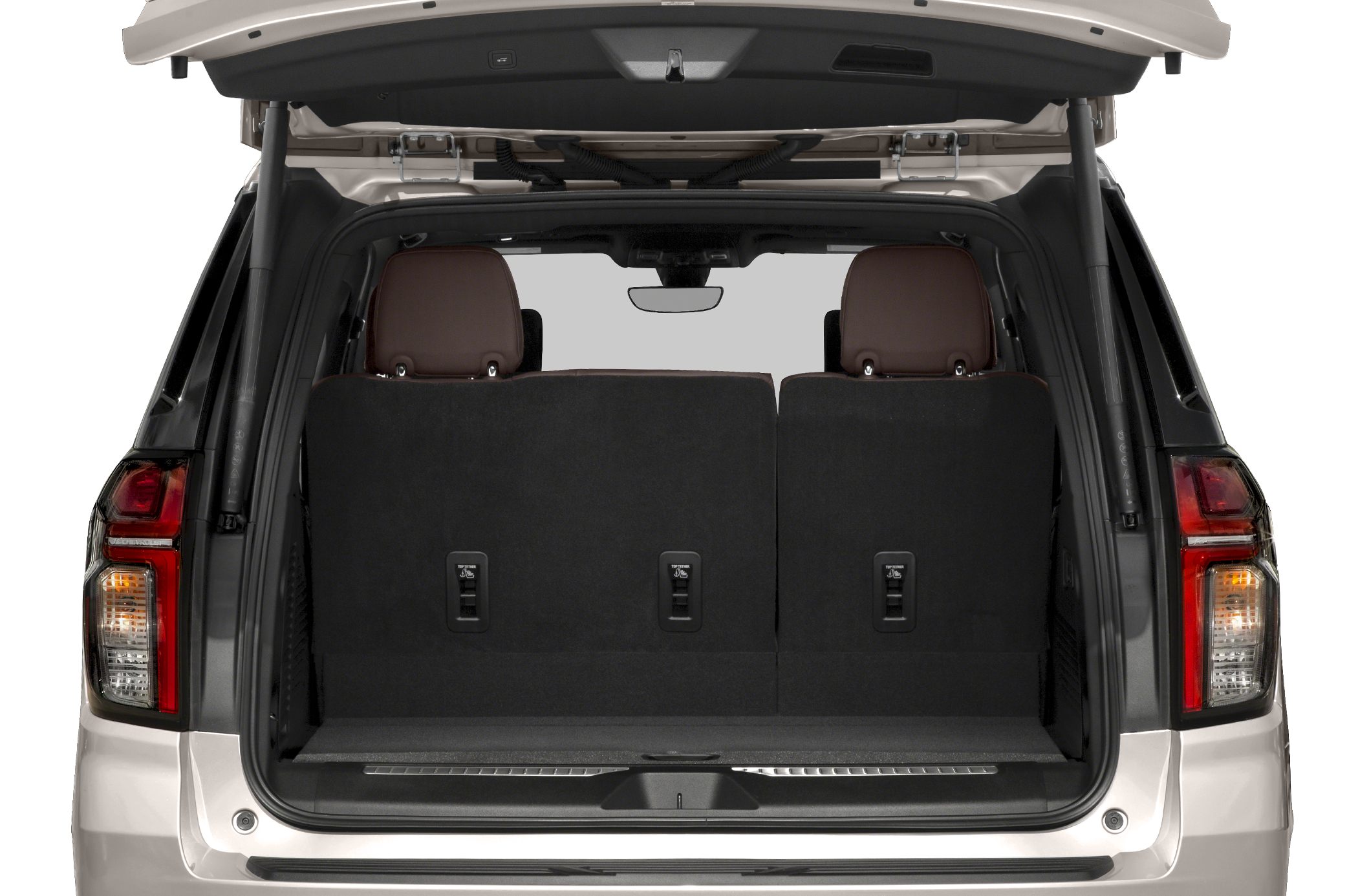 Rear cargo space with upright black seats and brown headrests