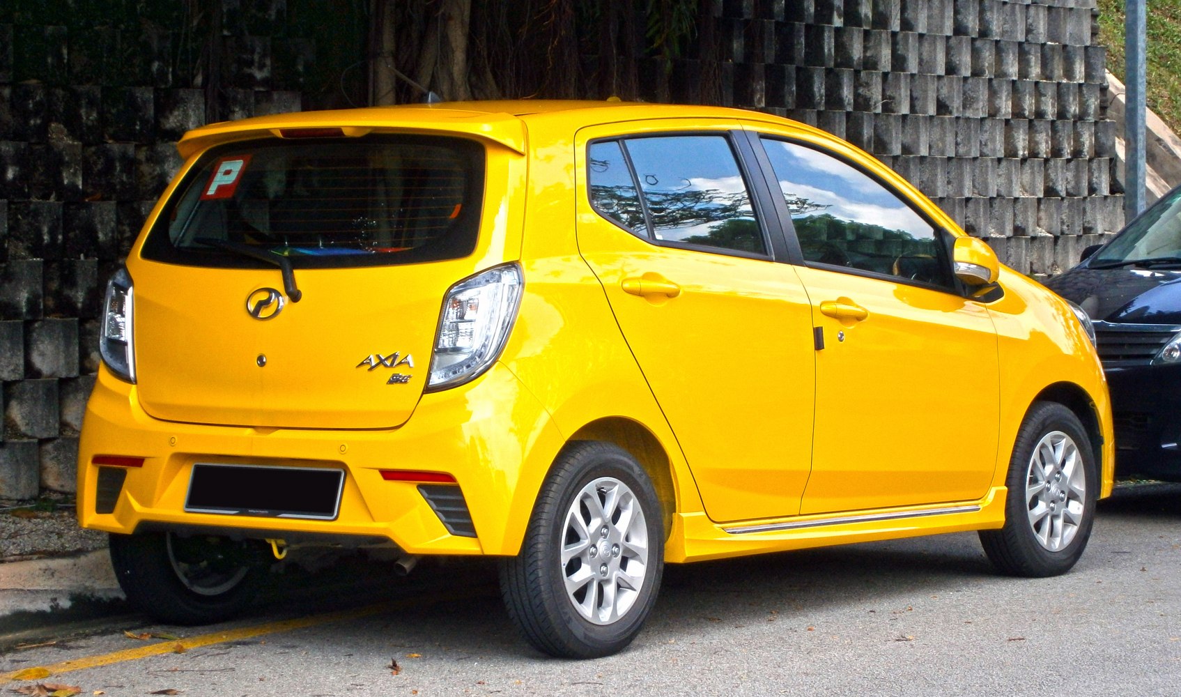 Compact yellow hatchback rear and side view with modern tail lights and bumper design.