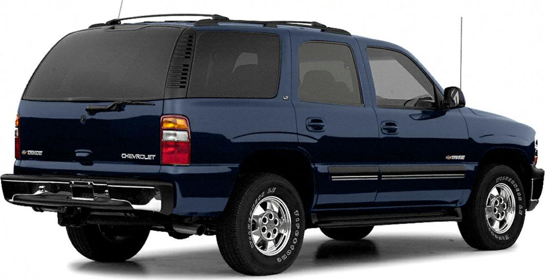 Rear side view of a dark blue 2000 SUV with rugged tires.