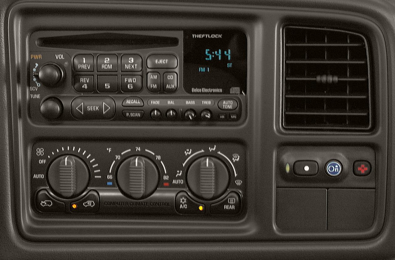 Climate control knobs, radio buttons, clock display, and OnStar button in a vehicle dashboard