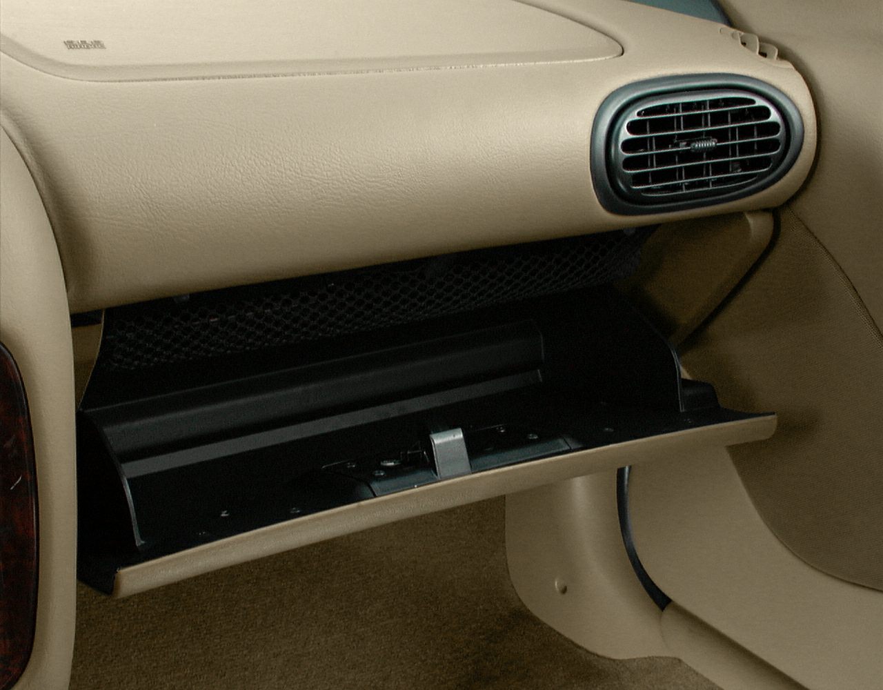 Beige glovebox and rounded air vent interior detail