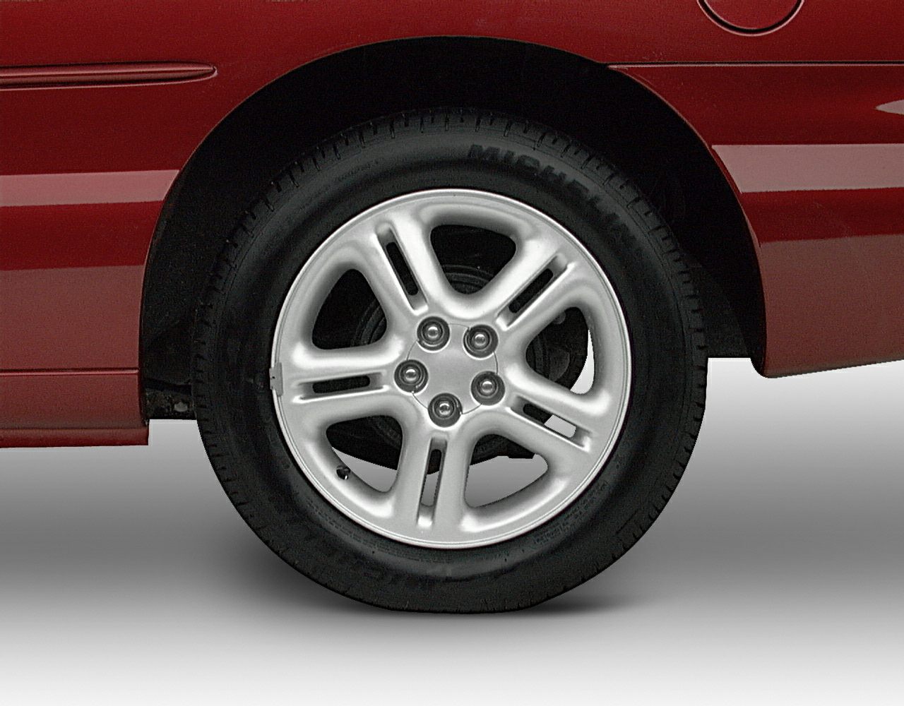 5-spoke alloy wheel design with lug nuts and tire.