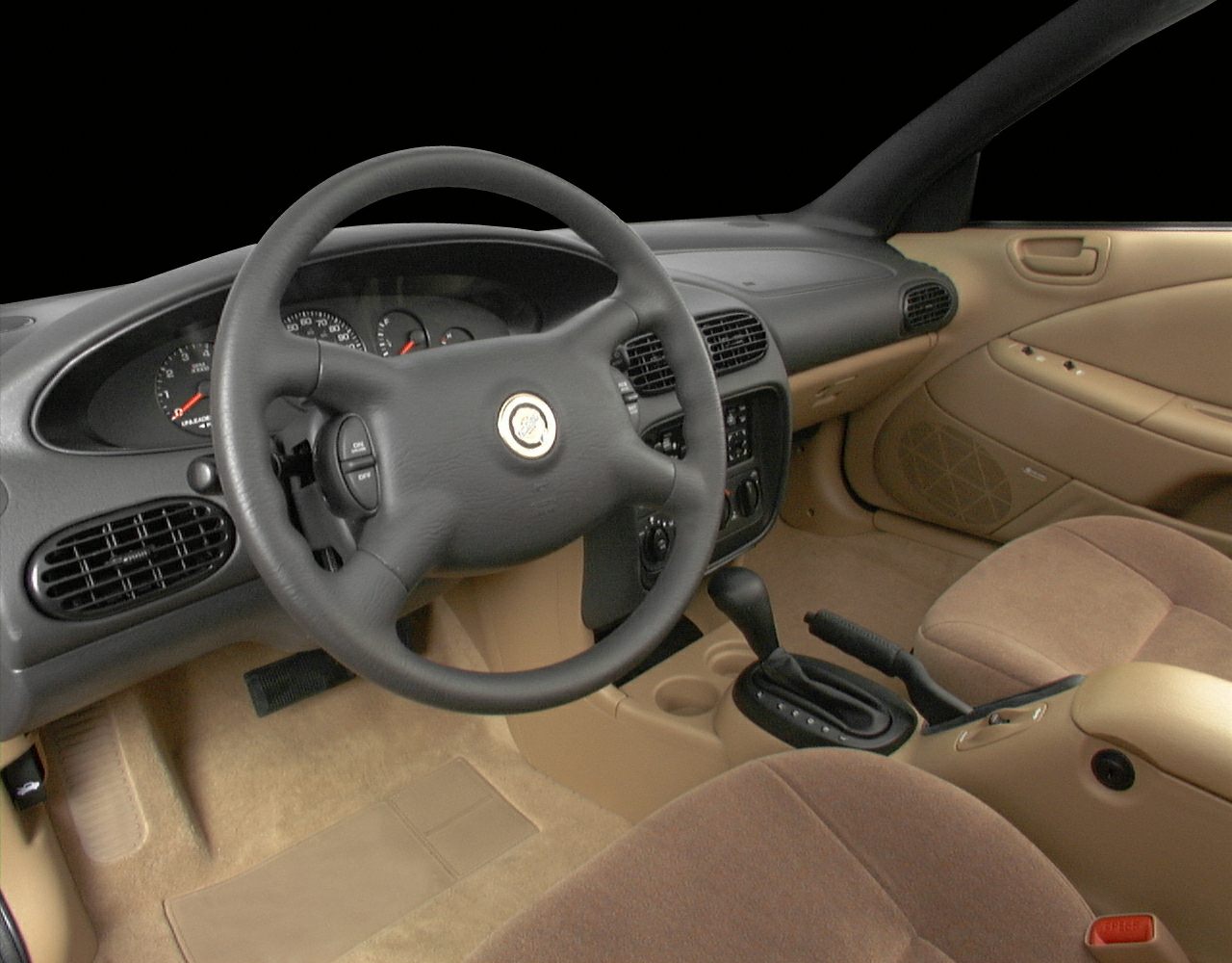 Dashboard and steering wheel with beige upholstery and automatic gear shift.