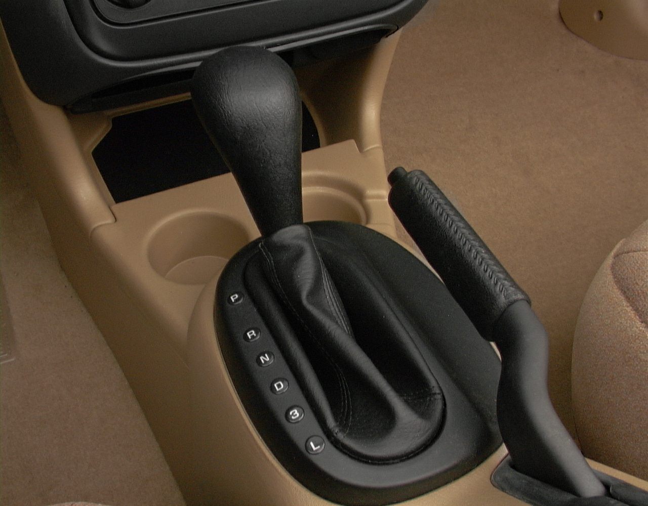 Automatic gear shift and handbrake close-up in beige interior