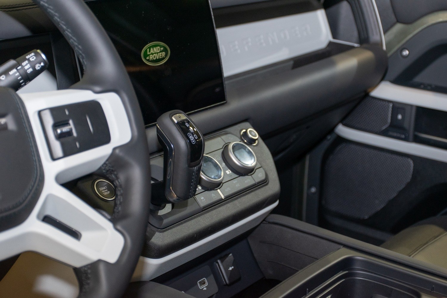 Close-up of gear selector and dashboard with control knobs in car interior