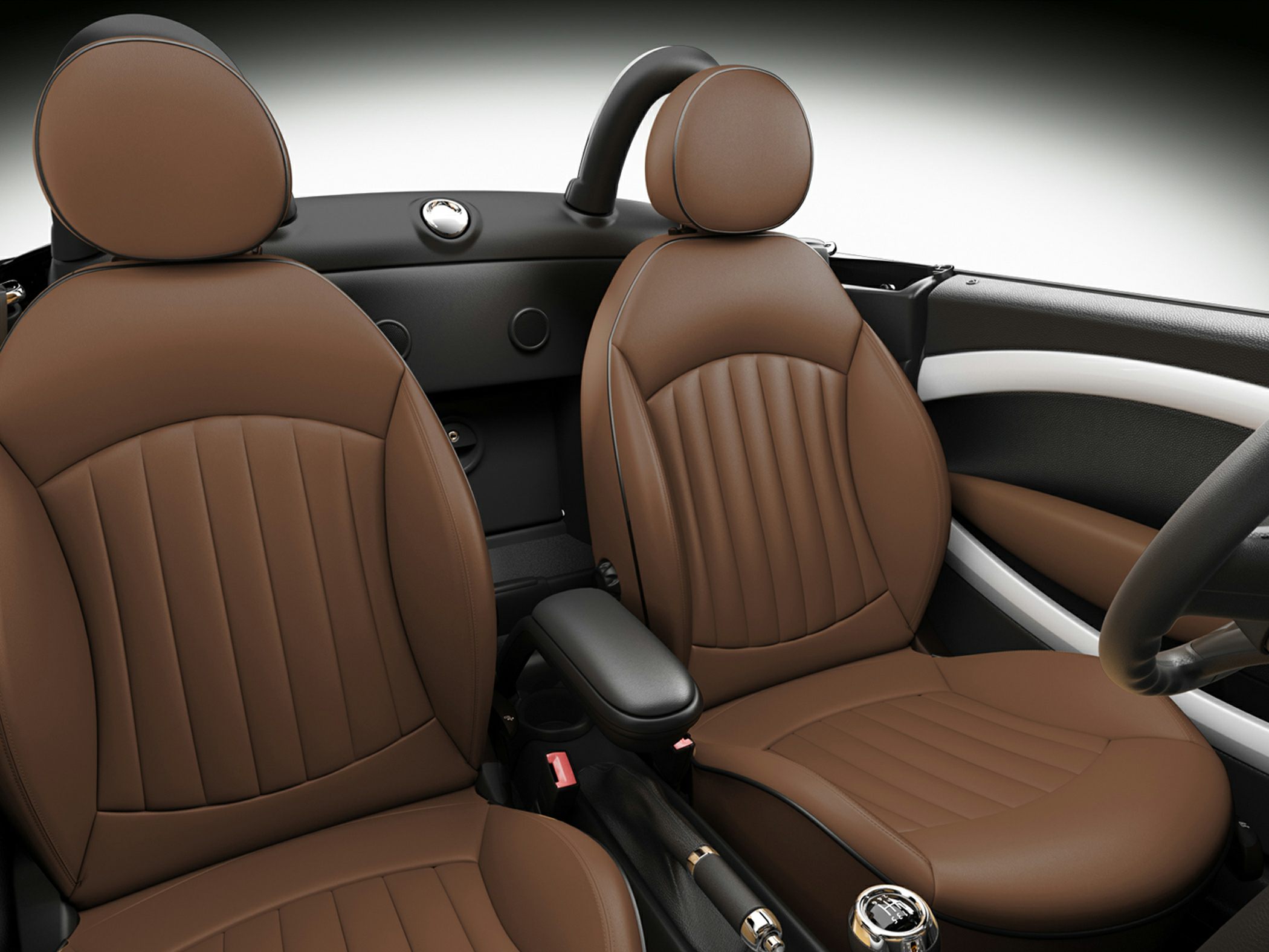 Brown leather car seats with vertical stitching and armrest in convertible interior