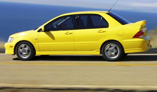Yellow sedan with rear spoiler and alloy wheels in motion