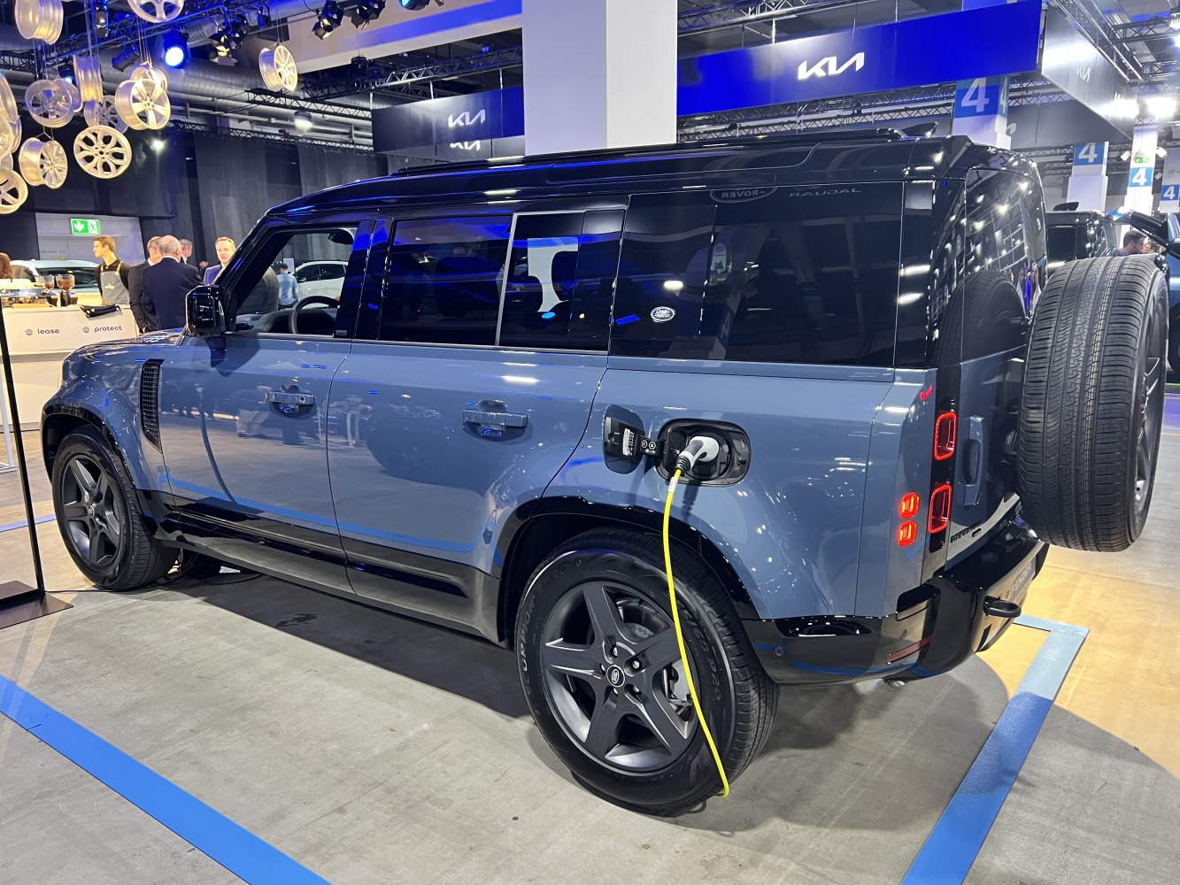 Electric SUV side view with charging port and rear spare wheel.