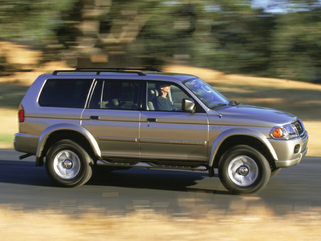 SUV side profile driving on road with blurred background