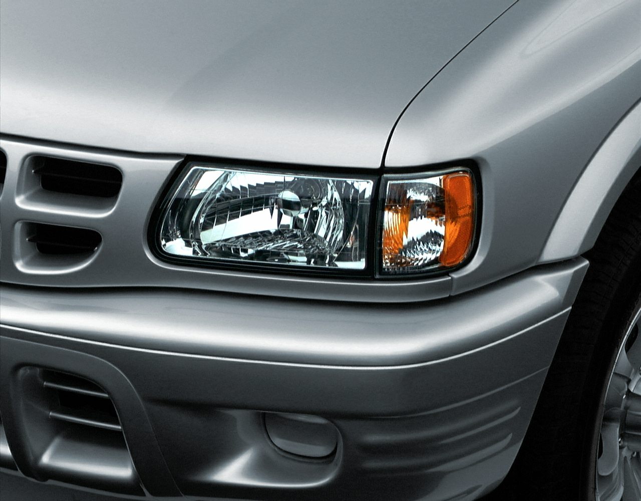 Close-up of front headlight and bumper details of a vehicle