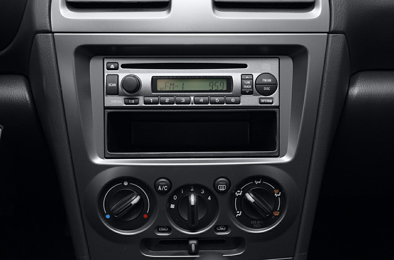 Car dashboard with radio unit and manual climate control knobs