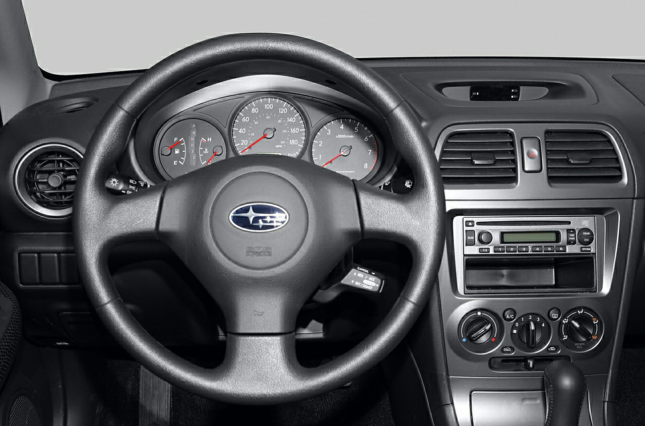 Steering wheel with brand logo and instrument cluster with gauges and center console controls