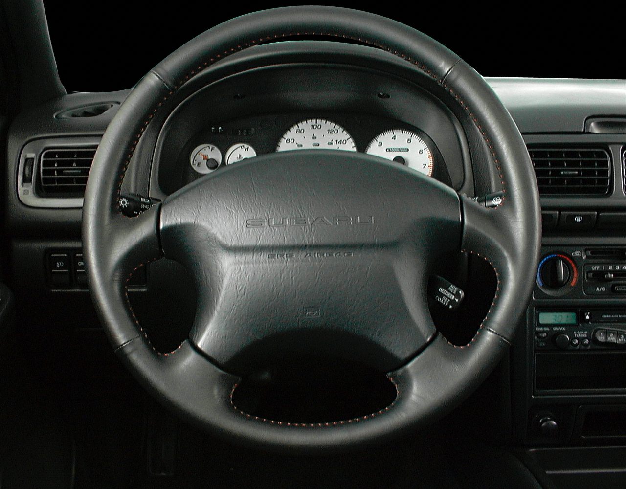 Leather steering wheel with dashboard gauges.