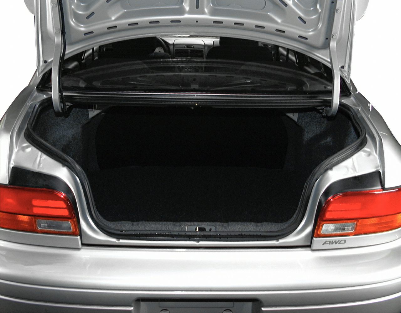 Open rear trunk and taillight details of a 1990s sedan with AWD badge