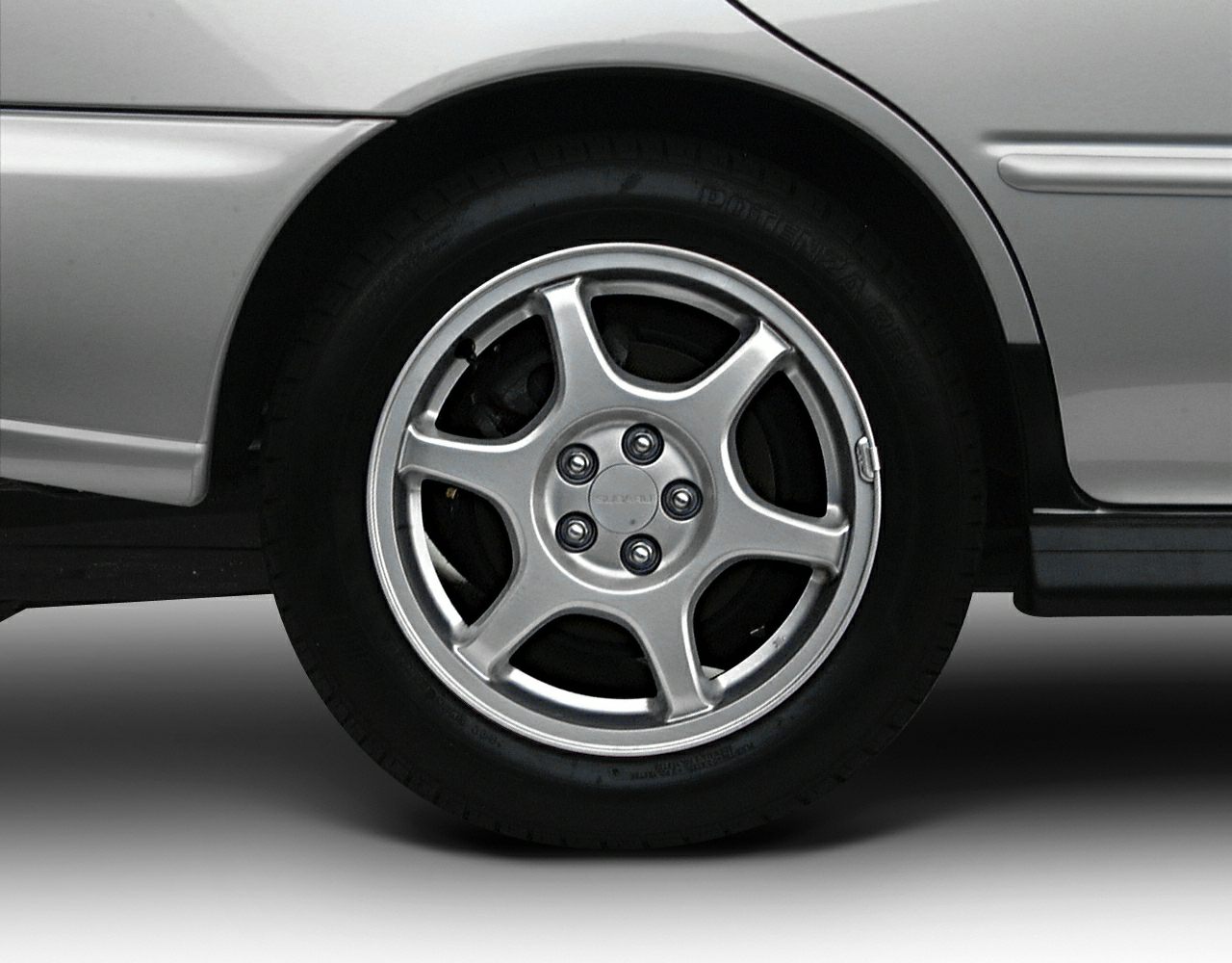 Five-spoke alloy wheel with tire and part of car fender