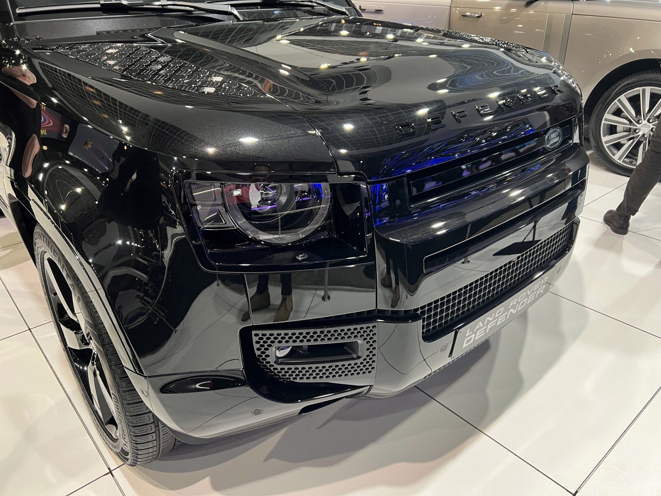 Close-up of front grille and headlight on glossy black SUV