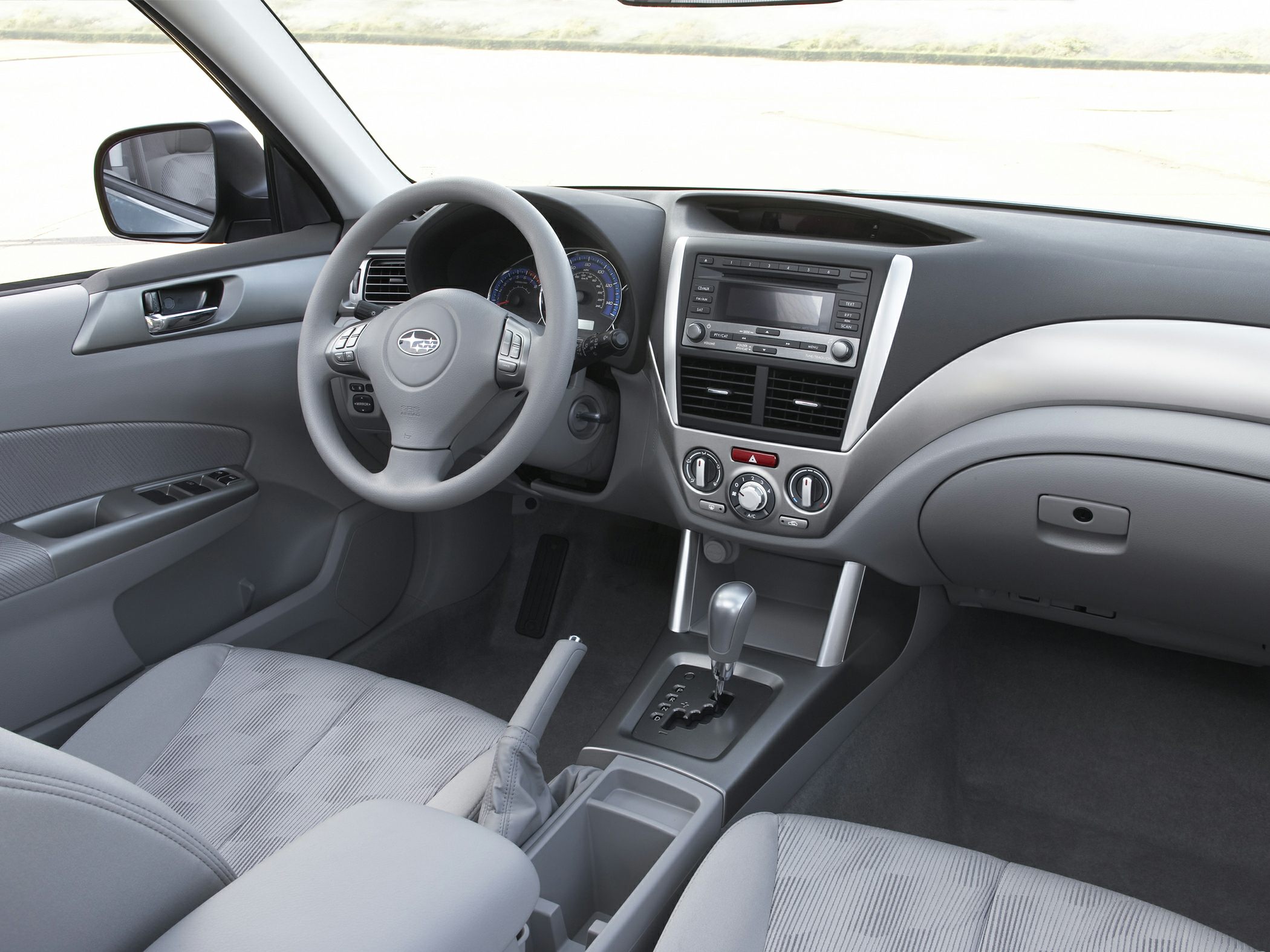 Steering wheel, dashboard, center console, and gear shifter inside a car