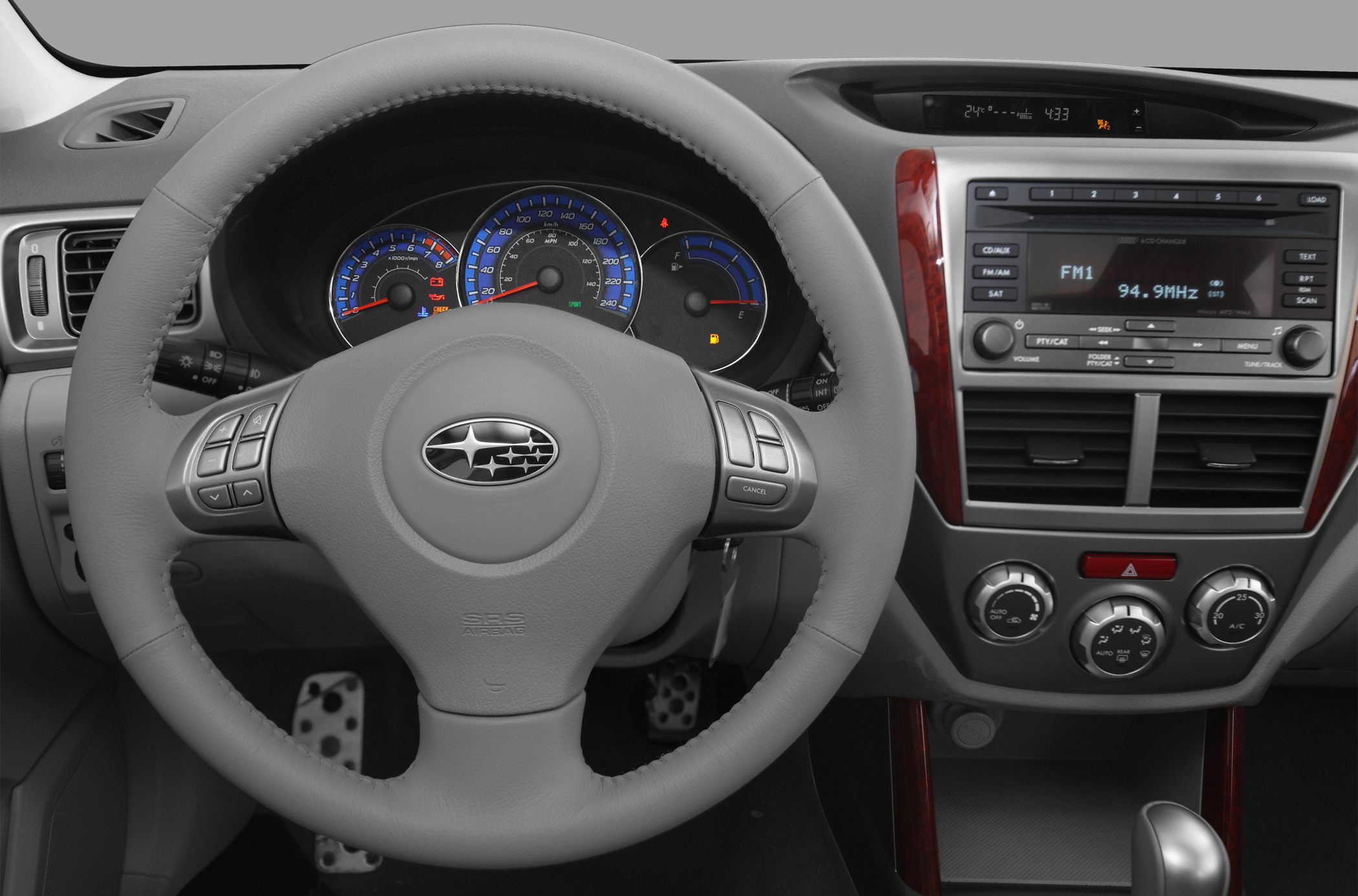 Steering wheel with controls and dashboard with speedometer and radio console