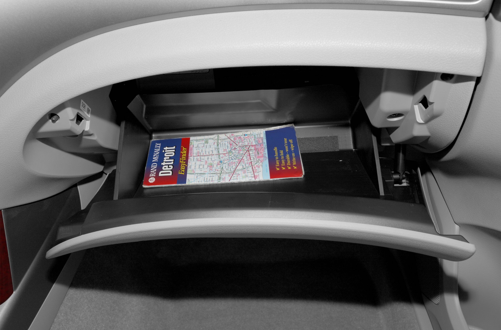 Open glove compartment with Detroit map inside.