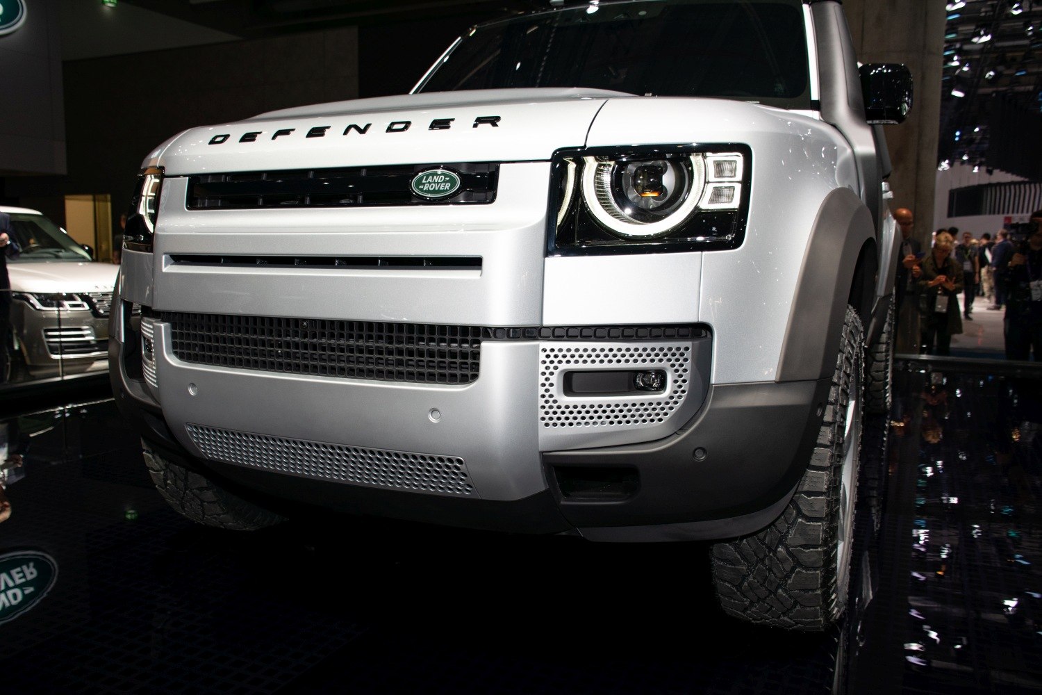 Close-up of front grille, LED headlight, and rugged off-road tire