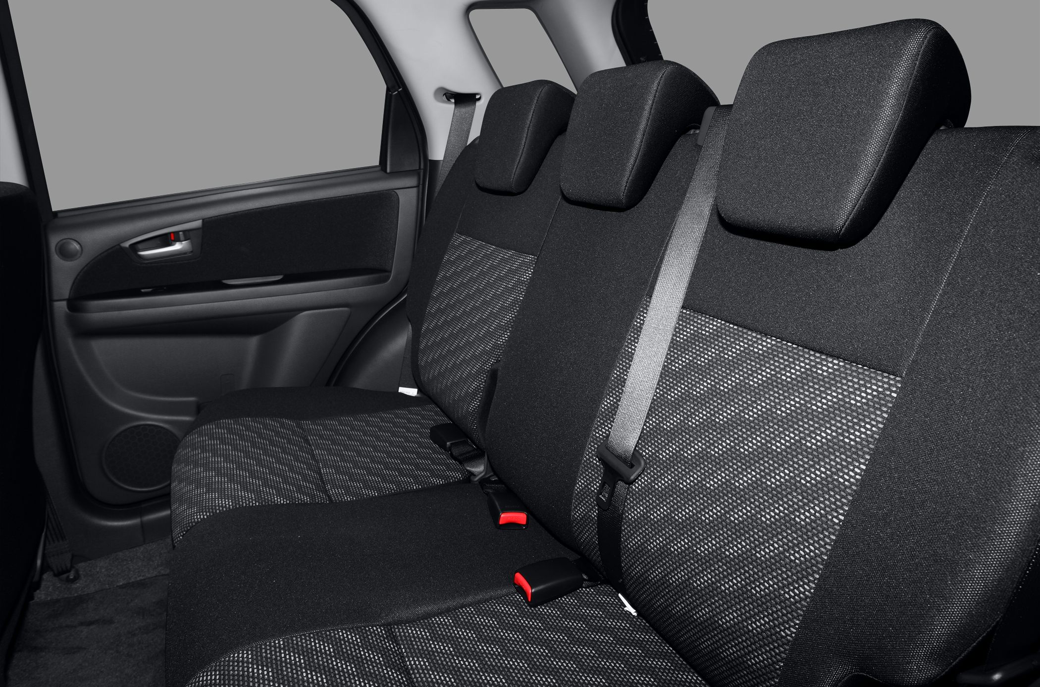 Rear seat interior with fabric upholstery and seat belts.