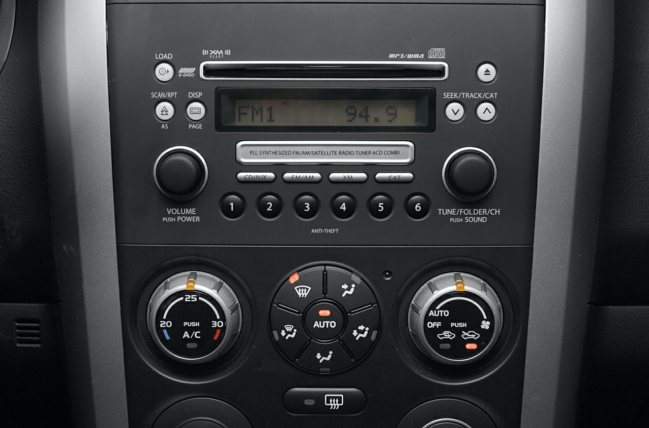 Close-up of car radio and climate control panel with knobs and buttons