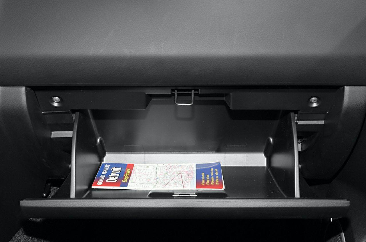 Open glove compartment with interior storage space and a folded map inside