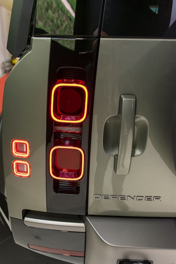 Close-up of rear tail lights and door handle with Defender badge
