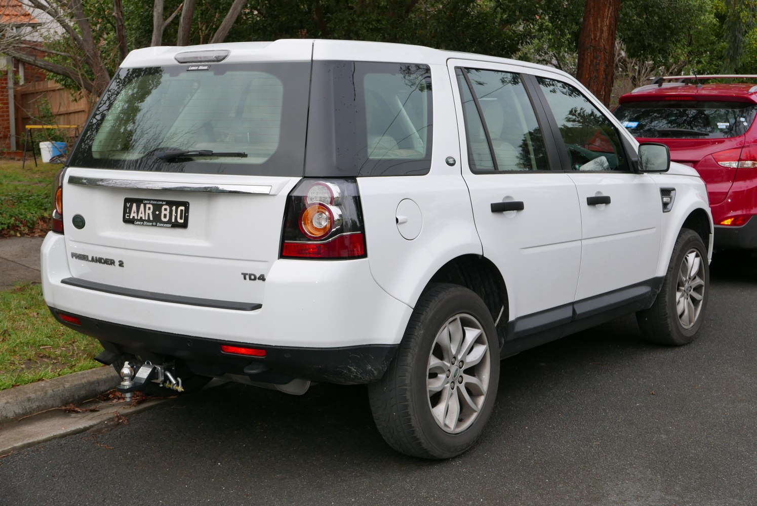 Rear view of white SUV with distinct taillights and tow hitch
