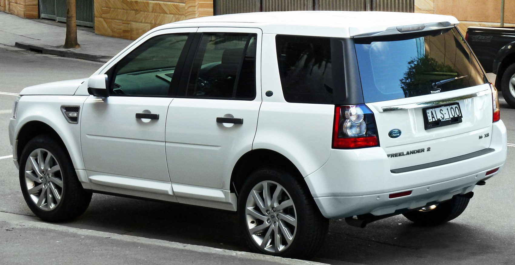 Rear-side view of white SUV with alloy wheels and tinted windows