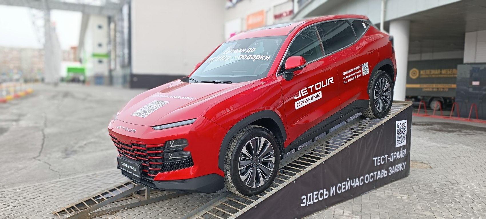 Red SUV with LED headlights and multi-spoke wheels on ramp